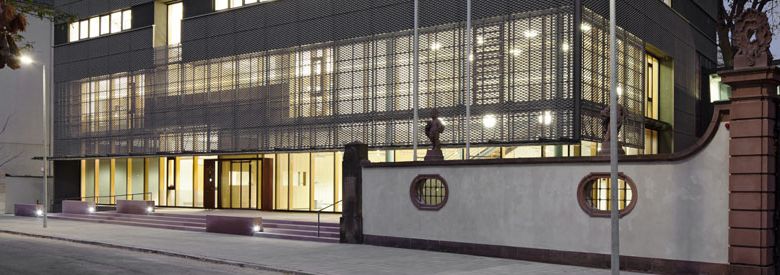 Foto des Neubaus des Generallandesarchivs Karlsruhe am Abend. Die Fenster des Gebäudes sind erleuchtet.
