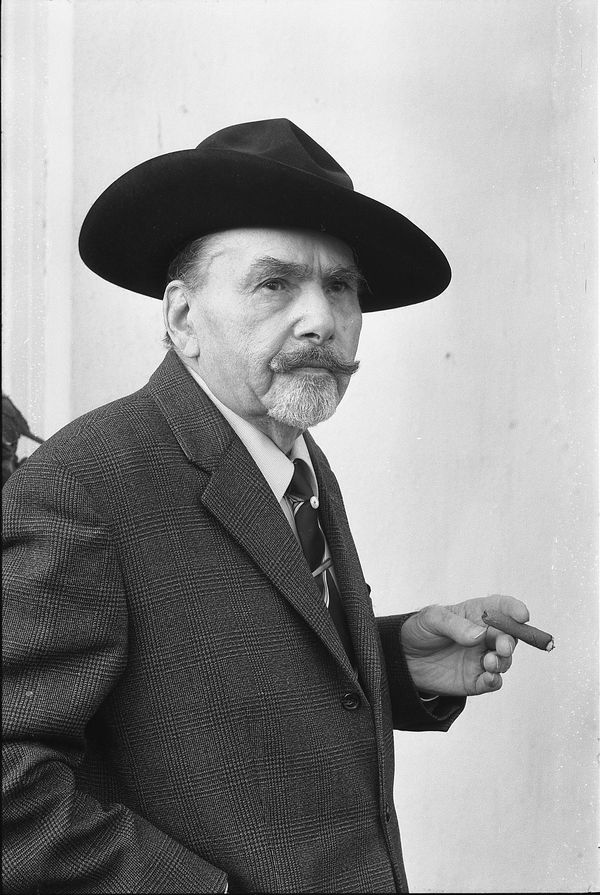 SW-Fotografie von Erwin Sammet. Halbfigur und Halbprofil; in der linken Hand eine Zigarre haltend; einen Hut tragend.