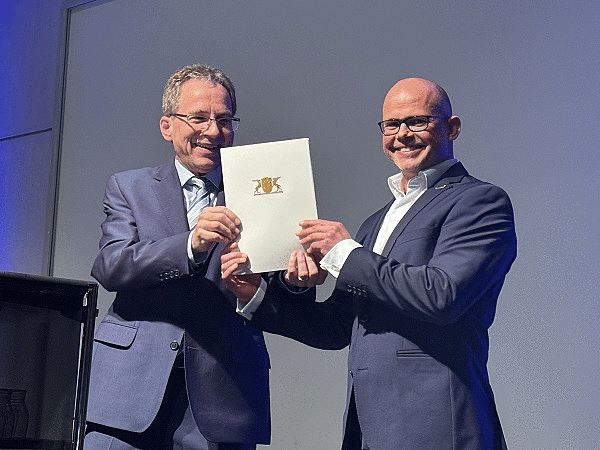 Prof. Dr. Gerald Maier überreicht Michael Aumüller seine Ernennungsurkunde 