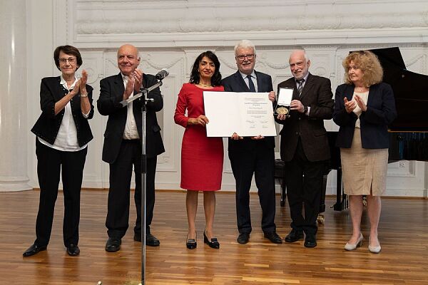 ruppenfoto mit sechs Personen: In der Mitte stehen Landtagspräsidentin Muhterem Aras und der Leiter des Generallandesarchivs Prof. Dr. Zimmermann, zusammen die Urkunde für Anton Maegerle zur Verleihung der Oppenheimer-Medaille in den Händen haltend. Rechts von ihnen steht ein Mann, der die goldene Oppenheimer-Medaille in einer offenen Schachtel hält.